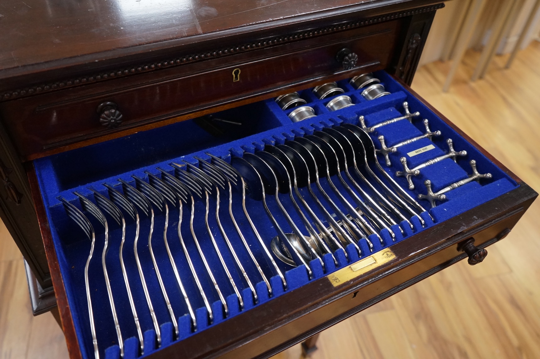 A canteen of cutlery by Viners, contained within a four drawer floor standing cabinet. 110cm tall